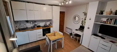 a kitchen with white cabinets and a wooden table at L'Alp'Inn - 4 pax, Chamonix Valley - Cozy Flat, Ski & Supermarket in Les Houches