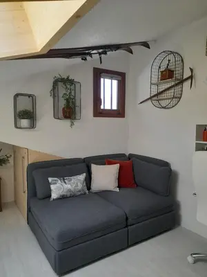 a blue couch in a living room with a window at Chalet mitoyen au calme - rez-de-jardin - parking in Les Houches