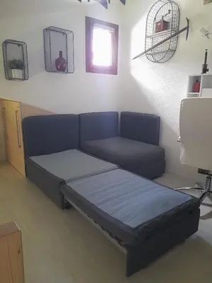 a bed in a room with a couch and a window at Chalet mitoyen au calme - rez-de-jardin - parking in Les Houches