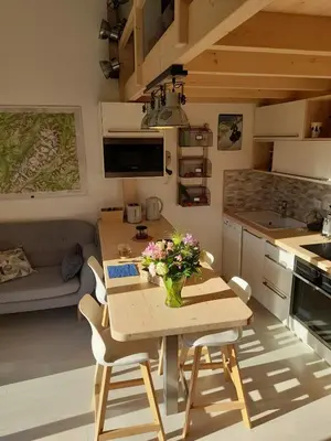 a kitchen with a table with a vase of flowers on it at Chalet mitoyen au calme - rez-de-jardin - parking in Les Houches