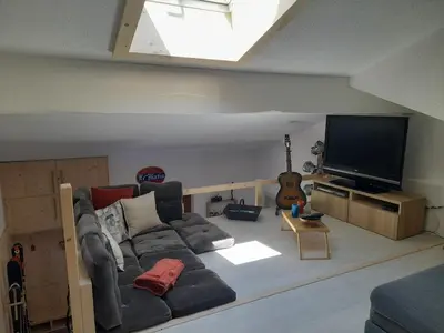 a living room with a couch and a flat screen tv at Chalet mitoyen au calme - rez-de-jardin - parking in Les Houches