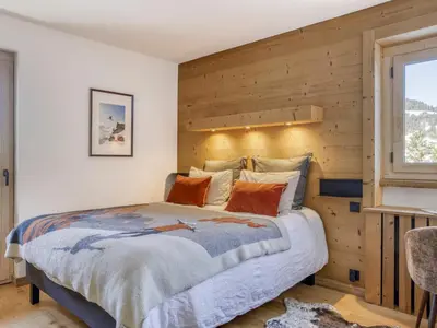 a bedroom with a bed with a wooden wall at Appartement 3 Chambres, Terrasse Sud/Ouest, Parking - Megève - FR-1-453-331 in Megève
