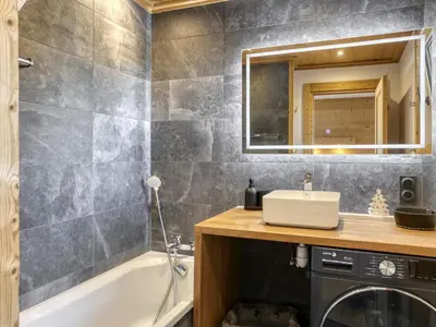 a bathroom with a sink and a tub and a mirror at Appartement 3 Chambres, Terrasse Sud/Ouest, Parking - Megève - FR-1-453-331 in Megève