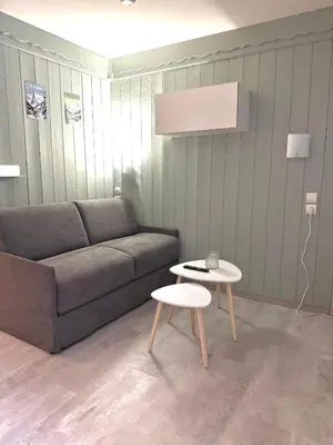 a living room with a couch and a table at Studio Cosy avec balcon in Combloux