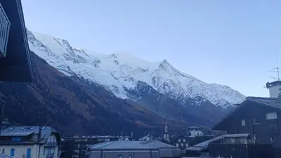 a snow covered mountain in the background of a city at Appt 4 pers Chamonix in Chamonix-Mont-Blanc