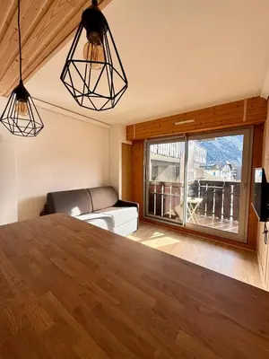a living room with a couch and a large window at Appt 4 pers Chamonix in Chamonix-Mont-Blanc