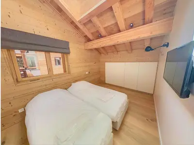 a small bedroom with a bed and a television at Appartement dans Chalet aux pieds des pistes in Arâches-la-Frasse