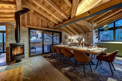 a dining room with a long table and a fireplace at Papillon Chamonix Chalet in Chamonix-Mont-Blanc