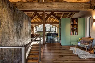 a living room with wooden ceilings and a staircase at Papillon Chamonix Chalet in Chamonix-Mont-Blanc