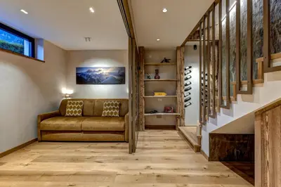 a living room with a couch and a staircase at Papillon Chamonix Chalet in Chamonix-Mont-Blanc