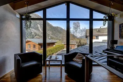 a room with two chairs and a large window at Papillon Chamonix Chalet in Chamonix-Mont-Blanc