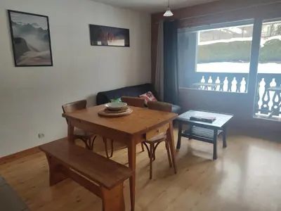 a living room with a wooden table and a couch at T2 pour 6 pers Les Houches in Les Houches