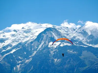 a person flying a kite over a snow covered mountain at T2 pour 6 pers Les Houches in Les Houches
