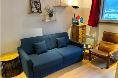 a living room with a blue couch and a chair at Apartment near Aiguille du Midi with balcony in Chamonix-Mont-Blanc