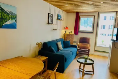 a living room with a blue couch and a table at Apartment near Aiguille du Midi with balcony in Chamonix-Mont-Blanc