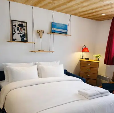 a bedroom with a large white bed and a dresser at Apartment near Aiguille du Midi with balcony in Chamonix-Mont-Blanc