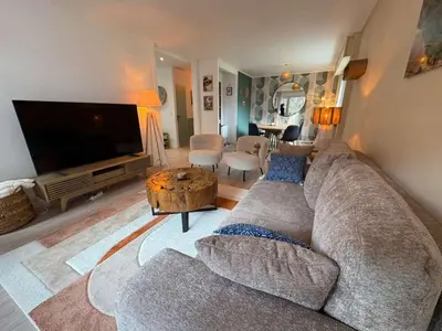 a living room with a couch and a large television at Modern Alpine Gem Flat with mountain views in Sallanches