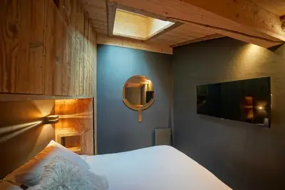 a bedroom with a bed and a mirror and a tv at Warm Alpine apartment 2BR 5P - Megeve in Megève