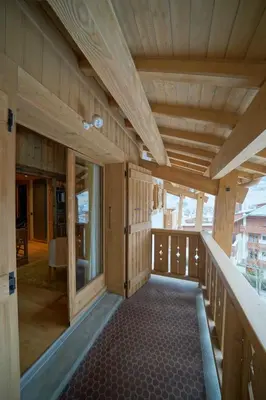 a large room with wooden walls and a balcony at Warm Alpine apartment 2BR 5P - Megeve in Megève