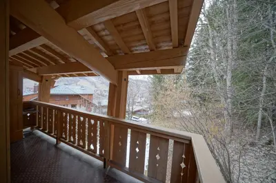 a balcony of a house with a wooden roof at Warm Alpine apartment 2BR 5P - Megeve in Megève