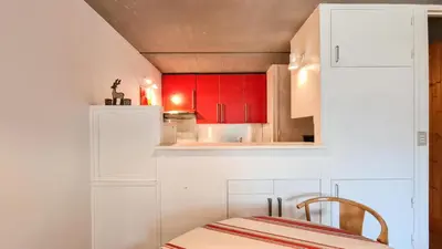 a kitchen with red cabinets and a white refrigerator at Résidence Aldebaran - Appartement spacieux avec casier à ski · Ski aux pieds · Balcon MAE-4994 in Magland