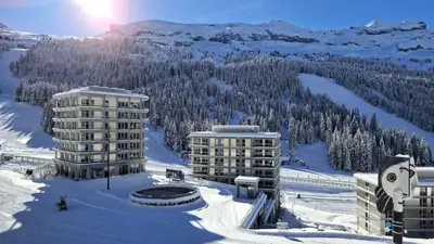 a view of two buildings in the snow at Résidence Aldebaran - Appartement spacieux avec casier à ski · Ski aux pieds · Balcon MAE-4994 in Magland