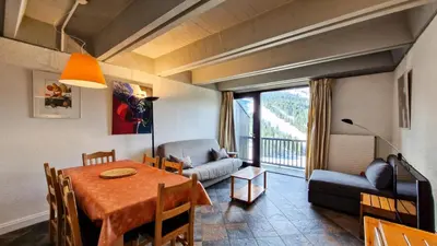 a living room with a dining room table and a couch at Résidence Aldebaran - Appartement spacieux · Départ et retour ski aux pieds · Balcon · Casier à ski MAE-5004 in Magland