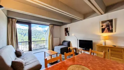 a living room with a couch and a table and a television at Résidence Aldebaran - Appartement spacieux · Départ et retour ski aux pieds · Balcon · Casier à ski MAE-5004 in Magland