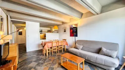 a living room with a couch and a table at Résidence Aldebaran - Appartement spacieux · Départ et retour ski aux pieds · Balcon · Casier à ski MAE-5004 in Magland