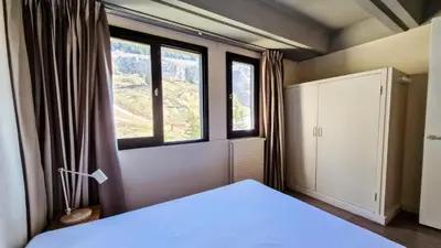 a bedroom with a bed and two large windows at Résidence Aldebaran - Appartement spacieux · Départ et retour ski aux pieds · Balcon · Casier à ski MAE-5004 in Magland