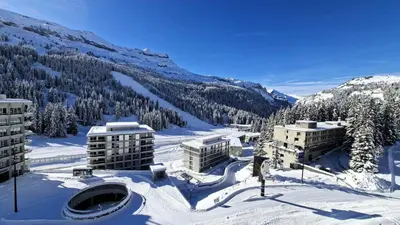 a person on skis in the snow in front of buildings at Résidence Aldebaran - Appartement spacieux · Départ et retour ski aux pieds · Balcon MAE-5024 in Magland
