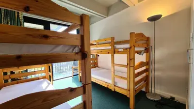 two bunk beds in a room with a window at Résidence Aldebaran - Appartement spacieux · Départ et retour ski aux pieds · Balcon MAE-5024 in Magland