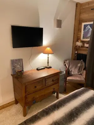 a bedroom with a wooden table with a tv on the wall at Megeve-Fully renovated Appartment- 10mn from village in Megève