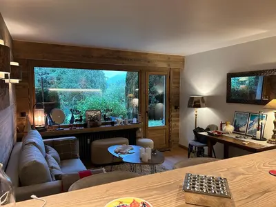 a living room with a couch and a large window at Megeve-Fully renovated Appartment- 10mn from village in Megève