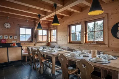 a dining room with a large wooden table and chairs at Chalet Uska - OVO Network in Combloux