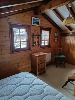 a bedroom with a bed and a desk and windows at Savoyard chalet 6pers exceptional view in Les Houches