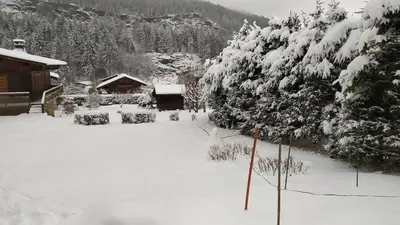 a snow covered yard with a house and trees at Savoyard chalet 6pers exceptional view in Les Houches