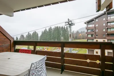 a balcony with a table and a view of a mountain at Gélinotte 23 - Station de ski à pied in Morillon