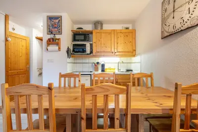 a kitchen and dining room with a wooden table and chairs at Gélinotte 23 - Station de ski à pied in Morillon