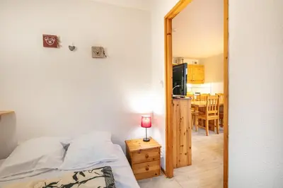 a bedroom with a bed and a mirror and a table at Gélinotte 23 - Station de ski à pied in Morillon