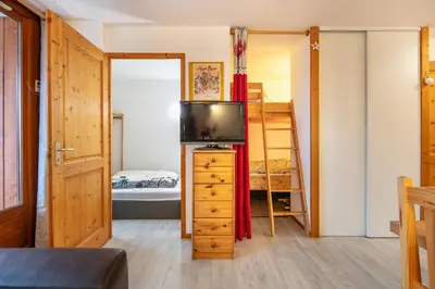 a bedroom with a tv and a bunk bed at Gélinotte 23 - Station de ski à pied in Morillon