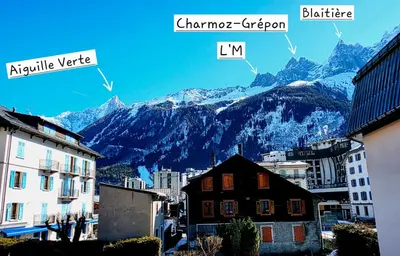 a balcony with a table and a view of mountains at Chez l'Alpiniste - Chamonix Center in Chamonix-Mont-Blanc