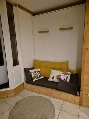 a couch in a room with pillows on it at Chez l'Alpiniste - Chamonix Center in Chamonix-Mont-Blanc