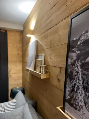a room with a wooden wall with a tv on it at Refuge du Lyret Cozy Central Chamonix, Garden, Pkg in Chamonix-Mont-Blanc
