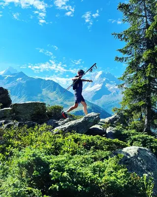 a man is running on a mountain with a stick at Refuge du Lyret Cozy Central Chamonix, Garden, Pkg in Chamonix-Mont-Blanc