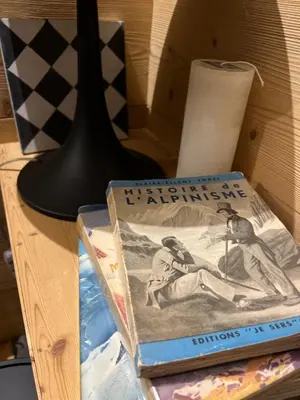 two books sitting on a table next to a lamp at Refuge du Lyret Cozy Central Chamonix, Garden, Pkg in Chamonix-Mont-Blanc