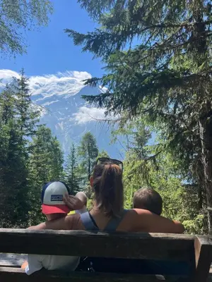 a family sitting on a bench looking at the mountains at Refuge du Lyret Cozy Central Chamonix, Garden, Pkg in Chamonix-Mont-Blanc