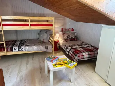 a room with two bunk beds and a table at Escapade aux Carroz in Arâches-la-Frasse