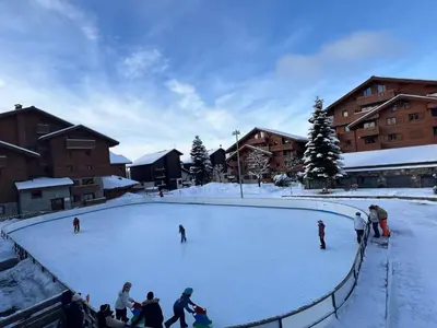 a group of people skating on a snow covered rink at Escapade aux Carroz in Arâches-la-Frasse