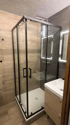 a glass shower in a bathroom with a sink at Escapade aux Carroz in Arâches-la-Frasse